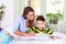 Mom helping little boy to do homework. Homeschooling during the coronavirus pandemic. Cute boy doing his school homework with his