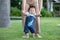 Mom helping and support baby learn to walk with love outdoors on grass. First steps of baby learning walk with family. Adorable