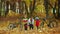 Mom helps children wear protective helmets in the autumn Park