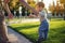 Mom helps cute baby walking on a green lawn in nature on a Sunny autumn day. Concept first child steps