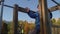 Mom helps happpy little boy to climb wooden attraction on playground