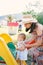 Mom helps a little girl climb the slide