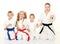 Mom with her daughter and a boy sitting with his sister in a ritual pose karate and beat his fist