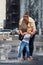 Mom with her son in the city by the water fountain. The little child is frightened by the sudden jets of water