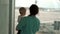 Mom with her son looking at airplane in airport.