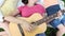 Mom with her two children play guitar at the park.