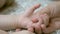 Mom is holding hand of little baby. Maternal care for small child. Close-up