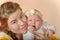 Mom holds the baby in her arms and poses for the camera in the studio, the concept of love and unity and care for loved ones and