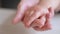 mom holds the hand of a newborn. close-up baby hand. hospital caring happy family medicine concept. baby newborn holding