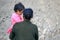 Mom holds on hands a little girl in a pink dress on a background of gray stone wall