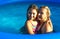 Mom hugs her daughter in the pool. Space for text.
