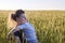 Mom hugs her little son on a wheat field in summer