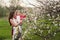 Mom hugs kisses daughter in the lush spring garden