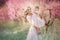 Mom with an infant in the rose garden with flowers trees