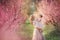 Mom with an infant in the rose garden with flowers trees