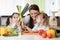 Mom and kids daughters have a fun preparing vegetables in a family home kitchen.