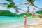 Mom and kids on palmtree on caribbean beach
