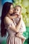 mom kiss daughter in pink dresses stand on a white background