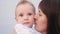 Mom kisses baby. Happy family little baby kid dream concept. Mom kisses and hugs little newborn son love. Portrait of a