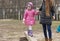 Mom leads daughter by hand through an obstacle.