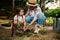 Mom learns her inquisitive daughter to grow plants, planting seedlings in ground. Love, care of nature since childhood