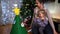 Mom with a little girl decorate a toy Christmas tree