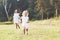 Mom and little girl have walk outside on the field and woods at background