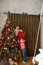 Mom with little sons decorates Christmas tree with red balls