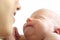 Mom looks at a smiling sleeping newborn baby close-up