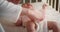 Mom lovingly puts a pink bodysuit on a newborn lying in diaper in a child crib