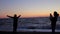 Mom makes daughter a photo at sunset on the sea. Handheld shot