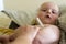 Mom measures the temperature of her baby with a mercury thermometer
