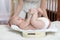 Mom is measuring baby weigh on scales at home