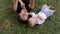 Mom with a newborn baby lying on the green grass and the Park in the summer.