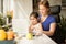 Mom and outgoing girl watching at the laptop screen while locating at the table