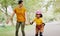 Mom, park and holding hands to rollerskate with child with care, learning and support. Interracial parent, teaching and