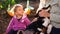 Mom petting a puppy while sitting next to her little daughter on the ground in the garden