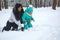 Mom plays with the child in the snow.