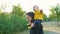 Mom plays with her child in the park at sunset. The boy sits on his shoulders in a yellow jacket and smiles happily