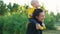 Mom plays with her child in the park at sunset. The boy sits on his shoulders in a yellow jacket and smiles happily