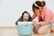 Mom plays with her son, he sits in a basket with clean laundry