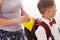 Mom puts a Packed school lunch in a plastic box for her son