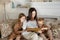 Mom reads a book to the children. A woman tells a story to a boy and a girl before going to bed. Mom daughter and son relax