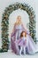 Mom and redhead baby daughter standing near wide arch shaped Christmas border