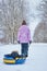 Mom rolls her little son on tubing in the Park in the winter. Happy family outdoors. winter fun for young children