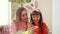 Mom rotates chicken yellow egg, and daughter draws on the blue dots with your fingers. on girl headband with rabbit ears