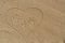 Mom`s, Dad`s and child`s handprints trace on the sand in heart.