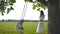 Mom shakes her babes, 1 and 3 years old, on a swing tied to an oak tree.