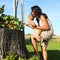 Mom showing flowers on stump to baby boy