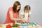 Mom shows daughter how to cut small knife mushrooms